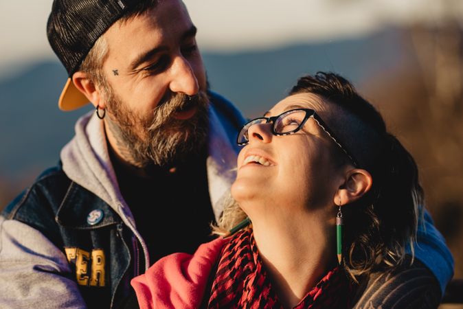 Happy couple hugging near tree in park
