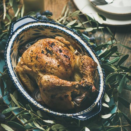 Centerpiece of roast chicken with decorative branches, square crop
