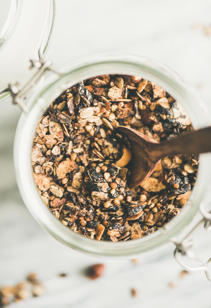Top view glass container of homemade granola, close up