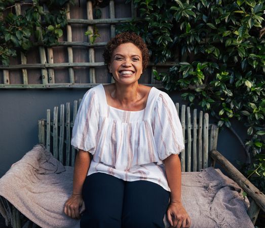 Smiling woman with short hair relaxing in backyard