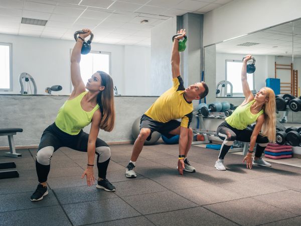 Athletes squatting with kettlebells
