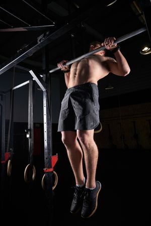Unrecognizable sportsman doing pull ups