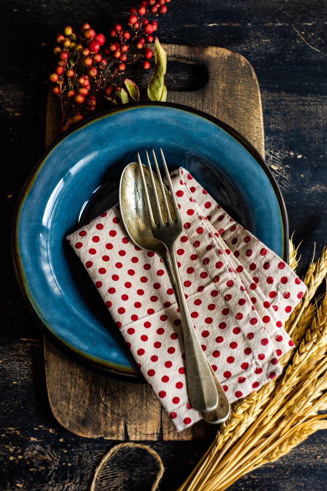 Autumn table setting with polka dot napkin, wheat and berry garnish