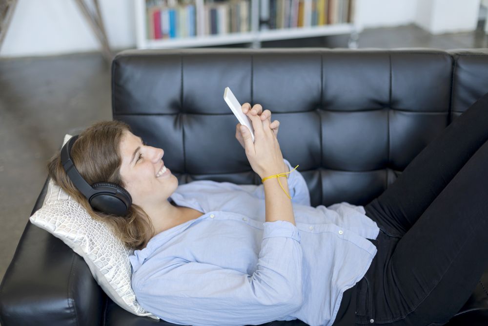 Beautiful young woman listening to music at home