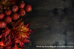 Autumn leaves with braid of onions on wooden table 418aL5