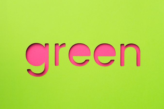 Green word made of paper over pink background