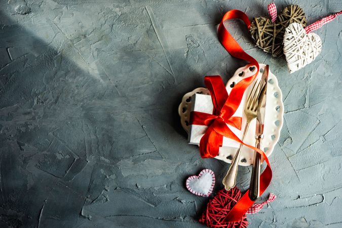 St. Valentine day table setting with heart plate and decorations with copy space