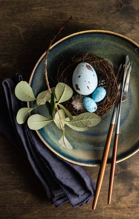 Top view of Easter table setting with ceramic plates and blue speckled eggs