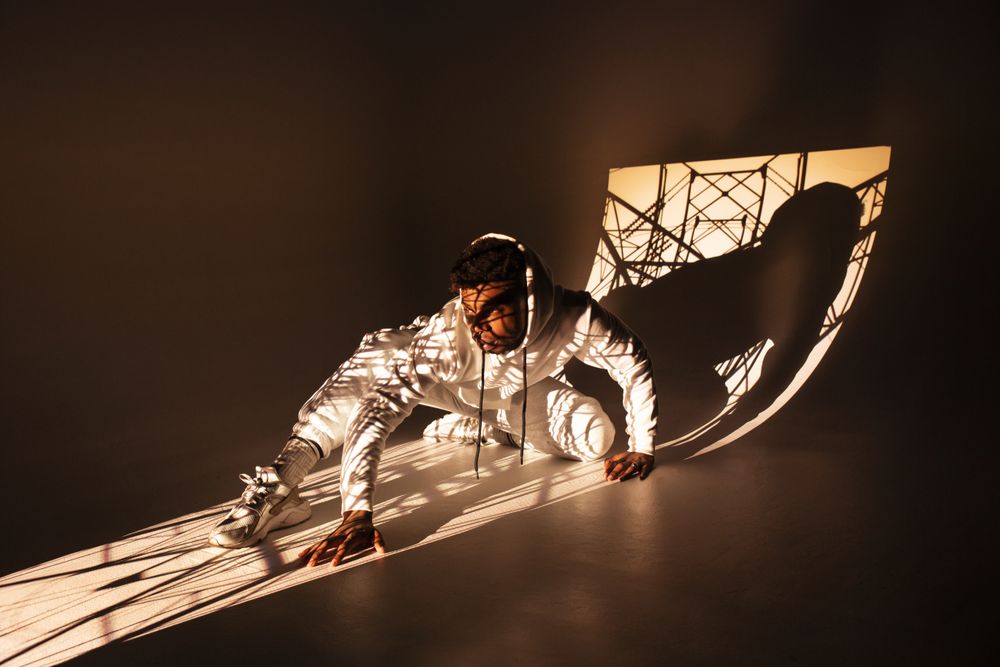 Black man dancing under bright light