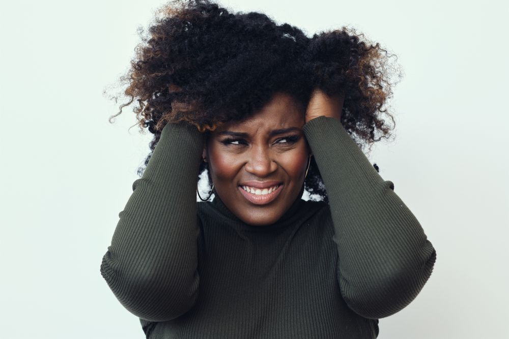 Confused Black woman with her hands in her hair