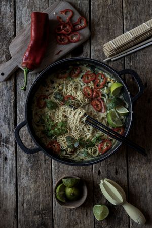 Green curry noodles in pot on table