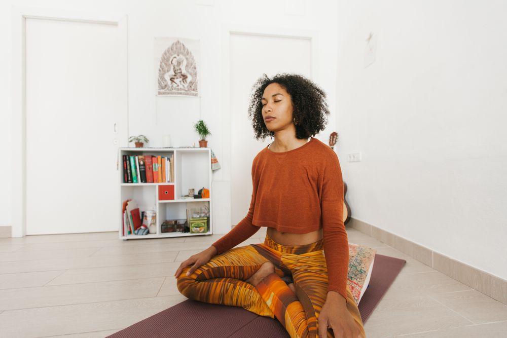 Sportive woman sitting in yoga pose with closed eyes