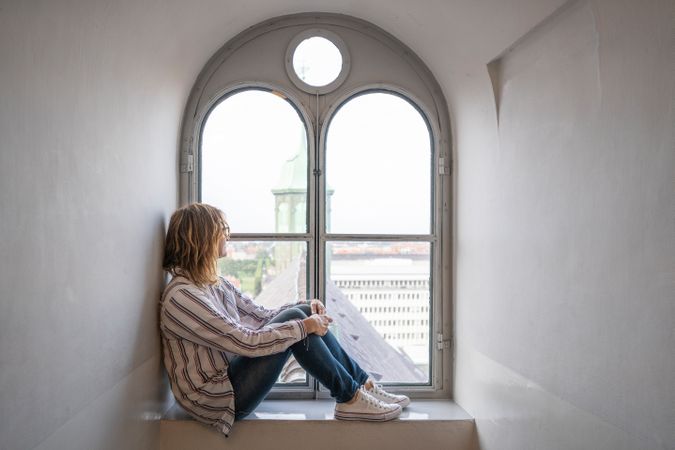 Relaxed woman resting in window sill