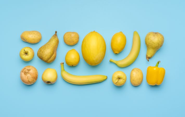 Yellow fruits and vegetables isolated on a blue background