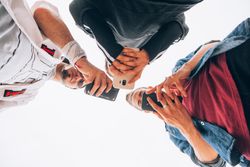 Stylish friends using smartphone outdoors