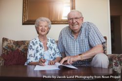 Portrait of a smiling older couple looking over documents bGqxB5