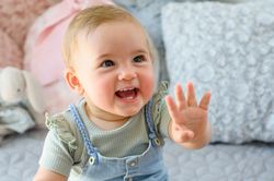 Charming baby with blond hair looking away