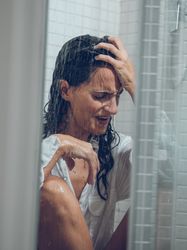 Frustrated female in shirt in shower