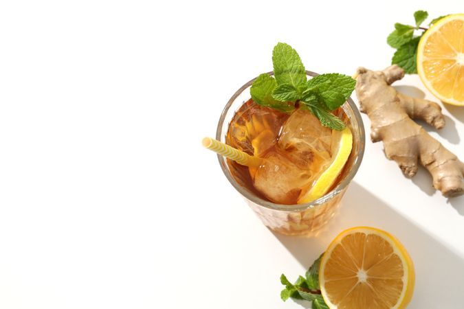 Cold tea with ice, orange slices and mint leaves and ginger