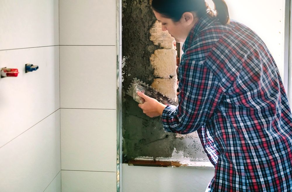 Female mason leveling cement with a trowel