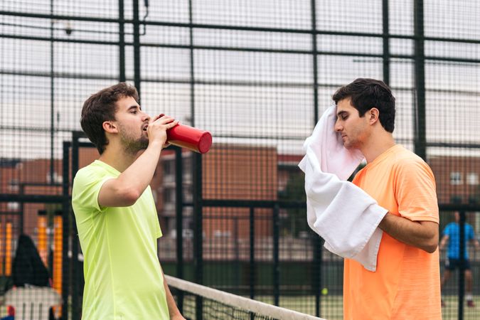 Two paddle tennis players resting after a game
