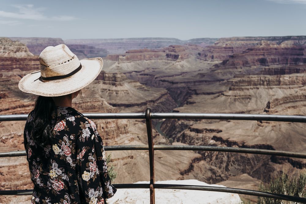 Tourist gazing while standing on edge of picturesque canyon
