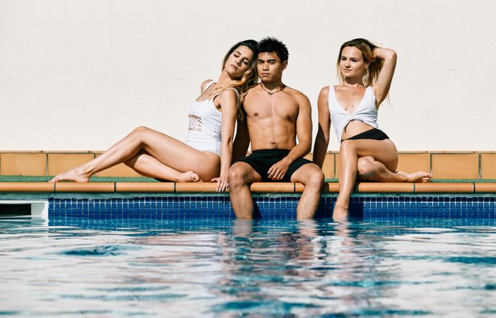a group of young models by the pool in a summer day