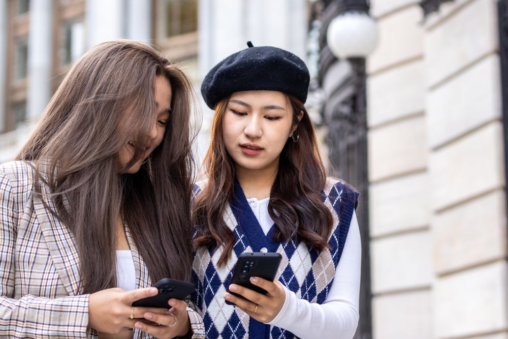 Young Asian Woman Walking and Using Smartphone in the City