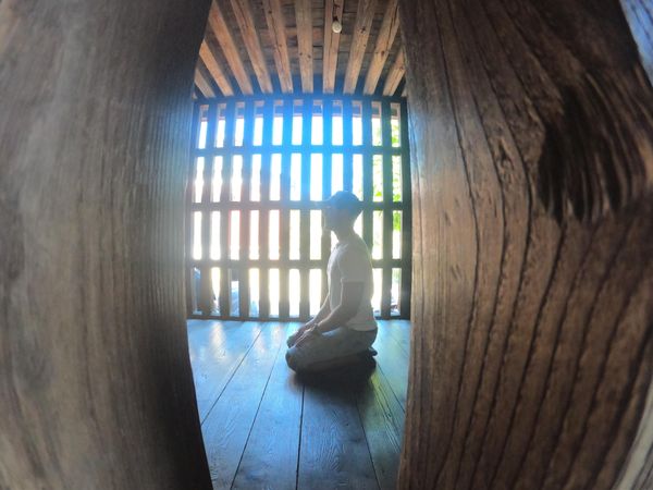 Side view of a man sitting on floor indoor