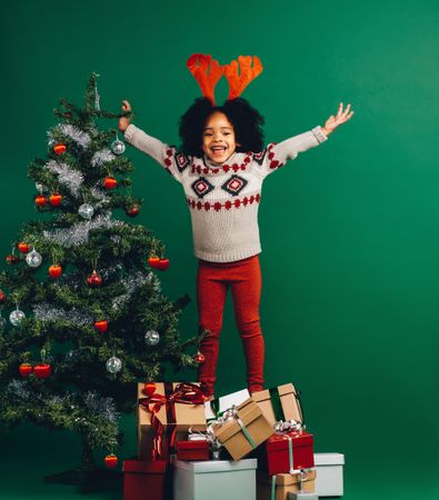 Excited little girl finished decorating a Christmas tree