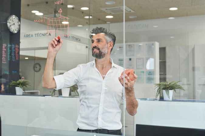Engineer writing information on glass during COVID pandemic