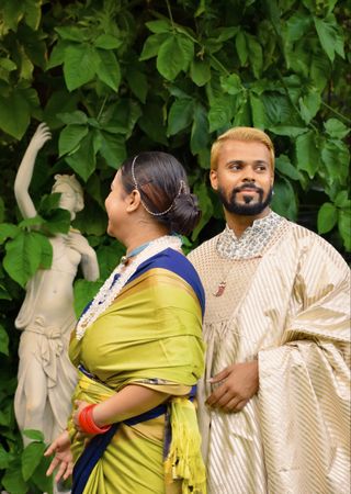 Indian man and woman standing beside a tree