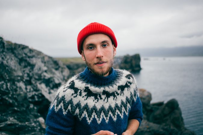 Portrait of man in woolen sweater on overcast day by the coast