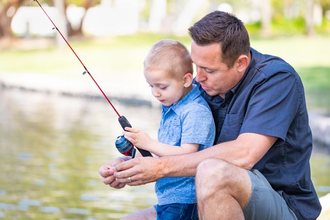 Father and Son Having Fun Fishing At The Lake