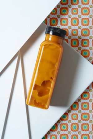 Mango and pumpkin smoothie bottle over retro textures