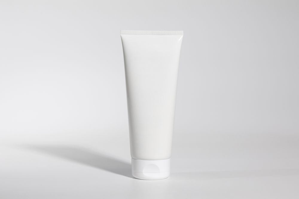Mockup of plastic tube of cream on plain background