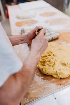 Bearded confectioner putting dough into cup
