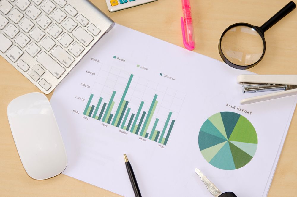 Workplace Desk with Sales Charts and Office Supplies