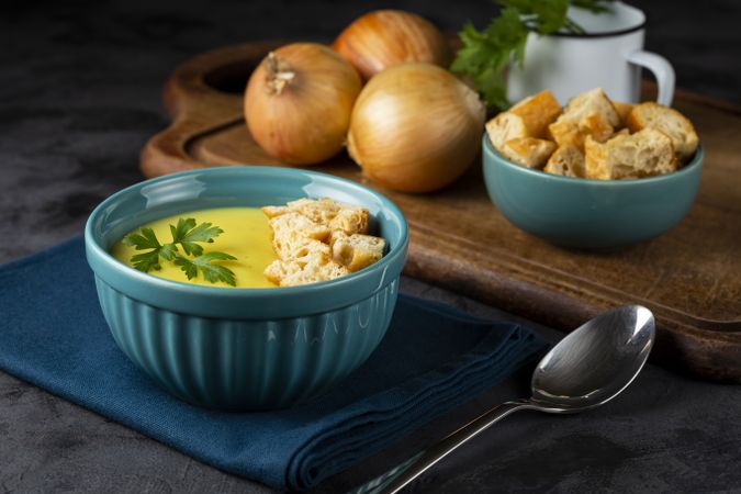 Bowl with onion soup and croutons on the table.