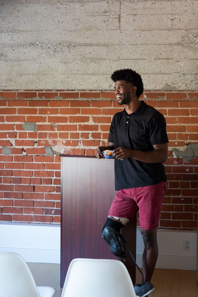 Man with prosthetic leg at podium in office