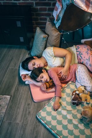Mother embracing to little daughter little asleep at night. Security and family protection concept.