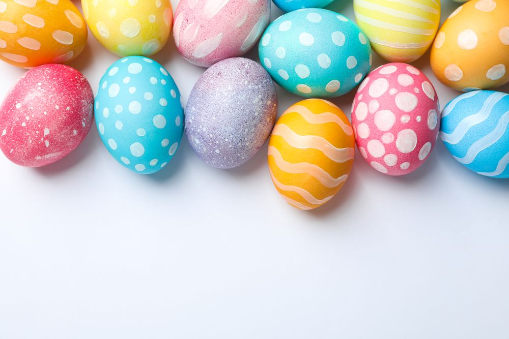 Decorative Easter eggs on neutral background, space for text. Top view