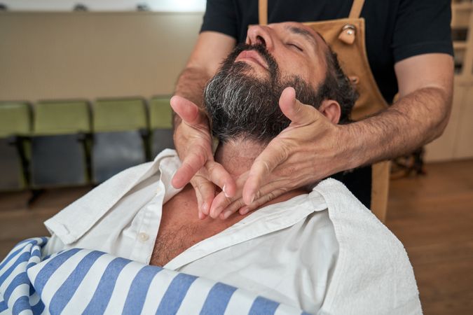 Crop barber moisturizing skin of client