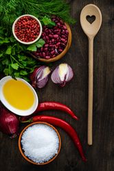 Top view of dried kidney beans and ingredients for chili on table with wooden spoon with heart