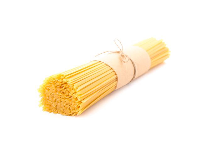 Pasta isolated on bright background, closeup. Dry uncooked whole pasta