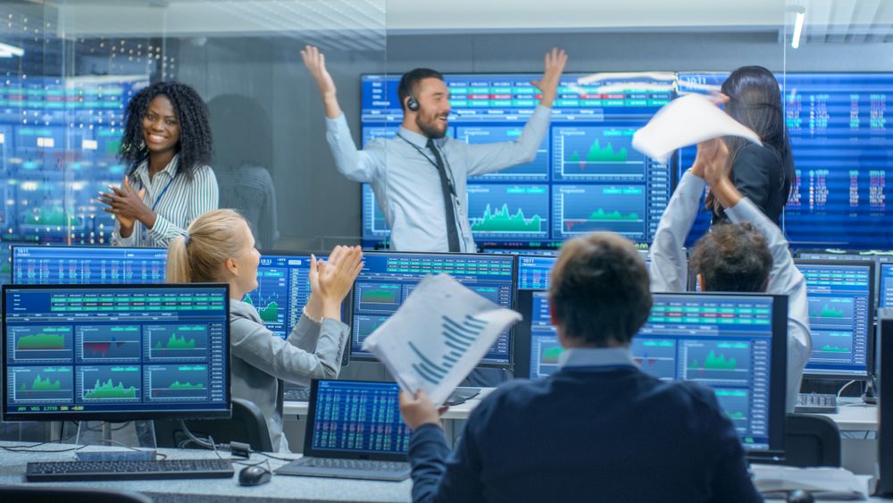 Multi-Ethnic Team of Traders Have Successful Day at the Stock Exchange Office.