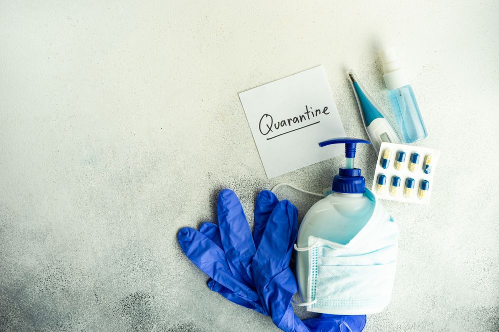 Soap wrapped in facemask with pills, thermometer and latex gloves with copy space