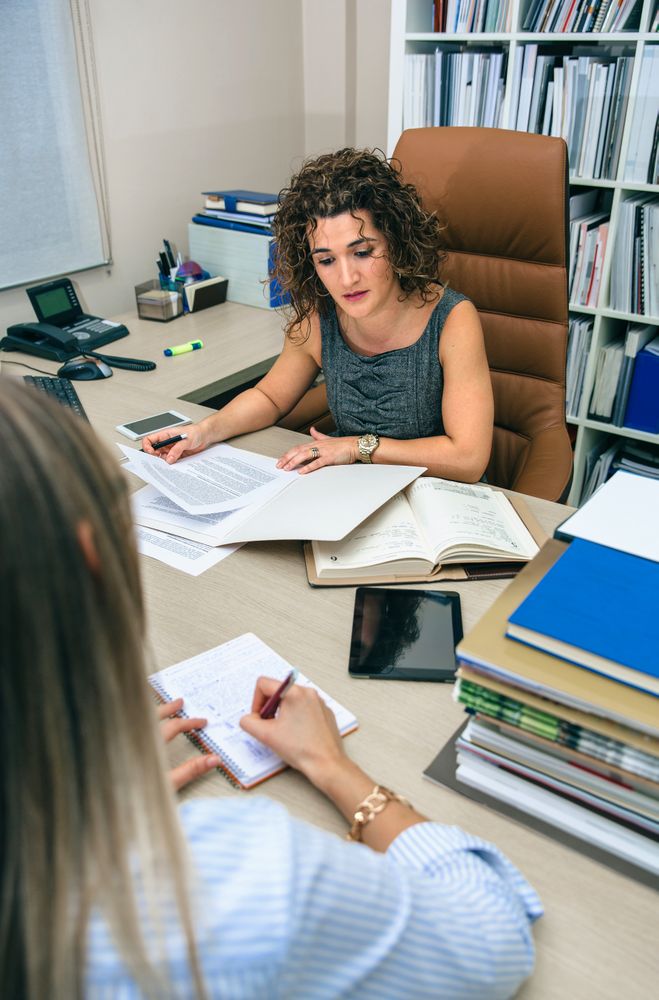 Two female colleagues going through documents in office