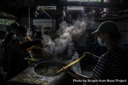 Group of workers with facemasks cooking for producing glossy noodles in Bogor, Indonesia 0yMQW0