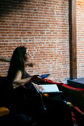 Woman sitting in theater with script and phone